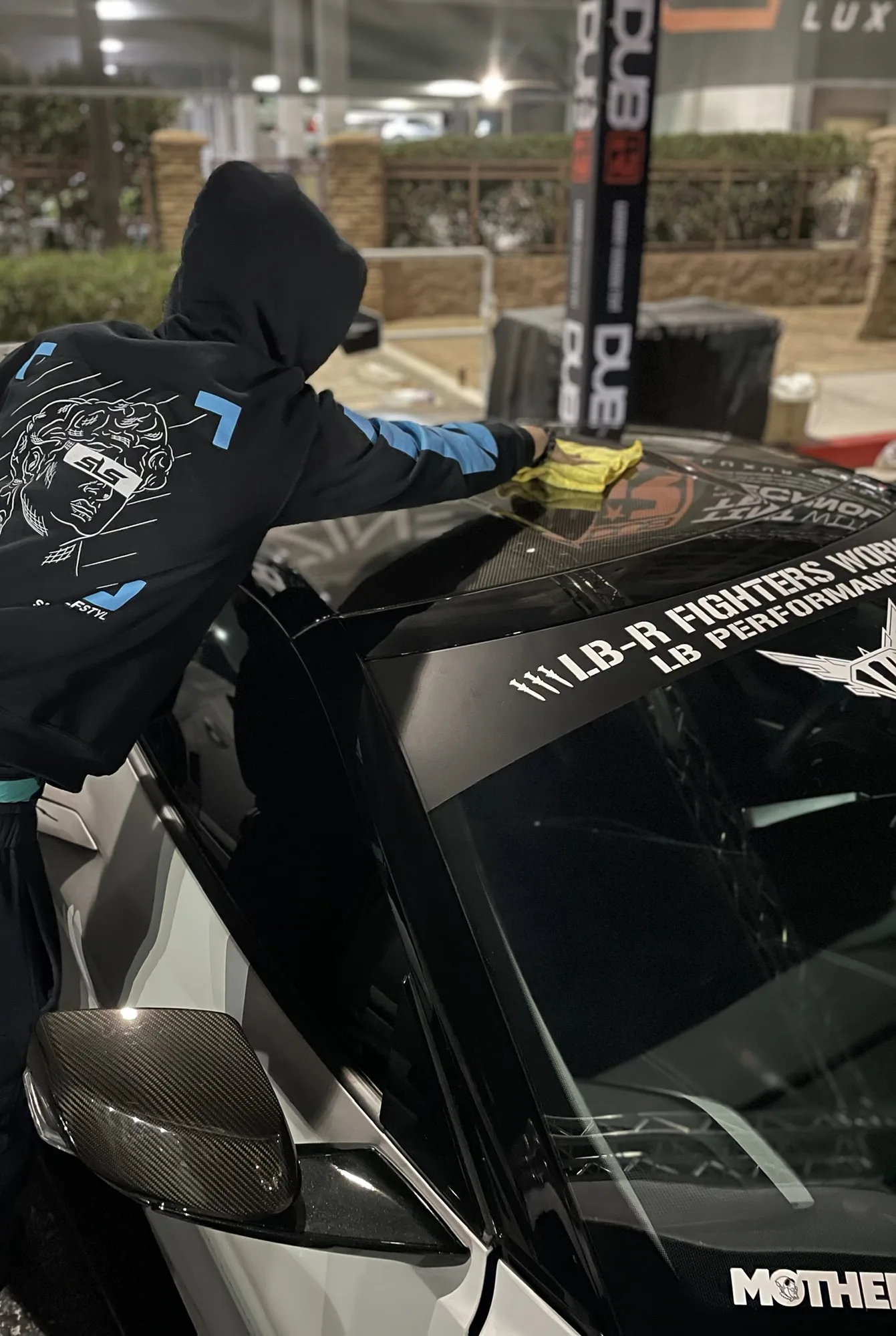 A worker wiping a vehicle roof during finish care