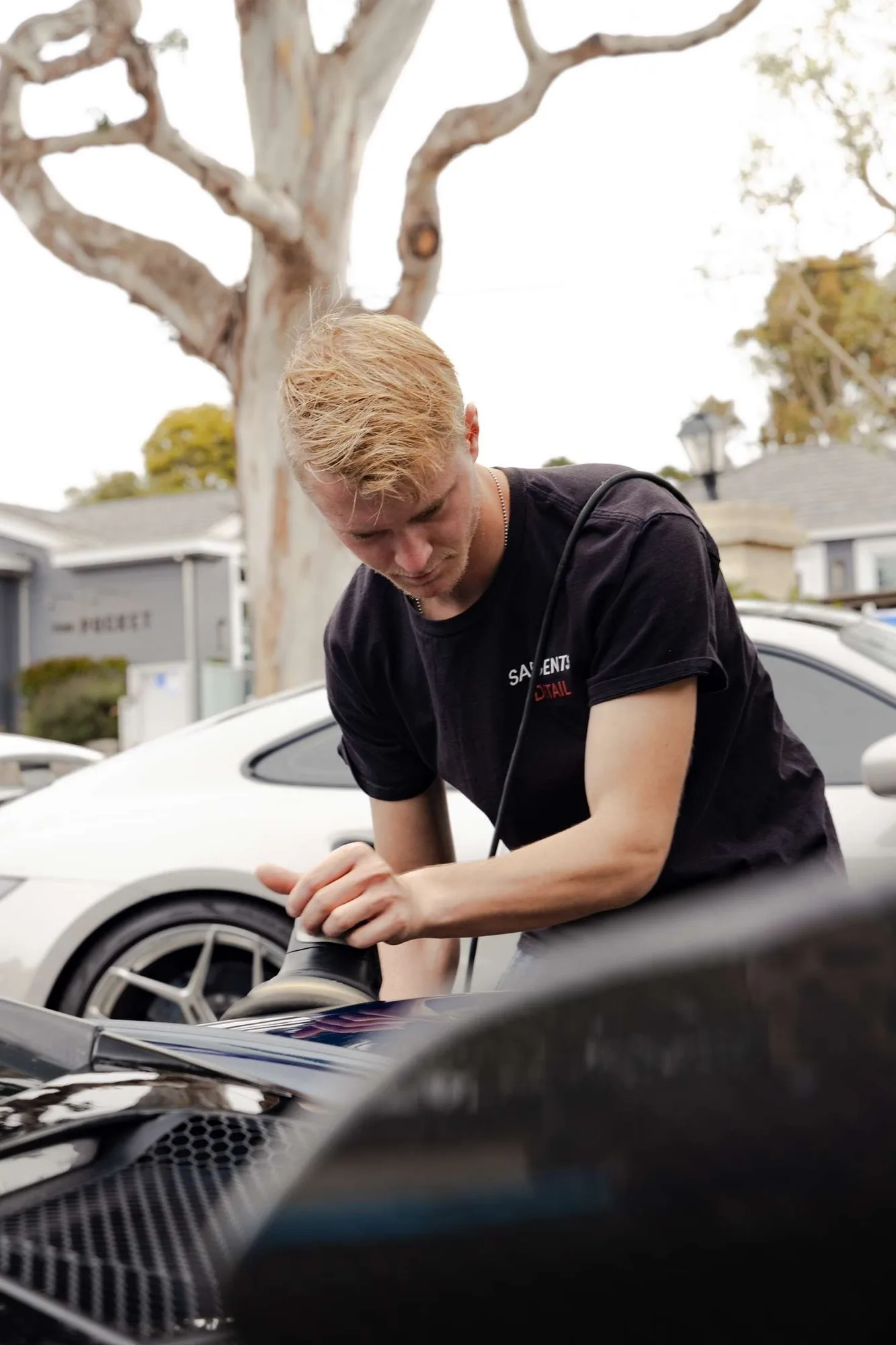 A Sargents Detail worker polishing a vehicle surface