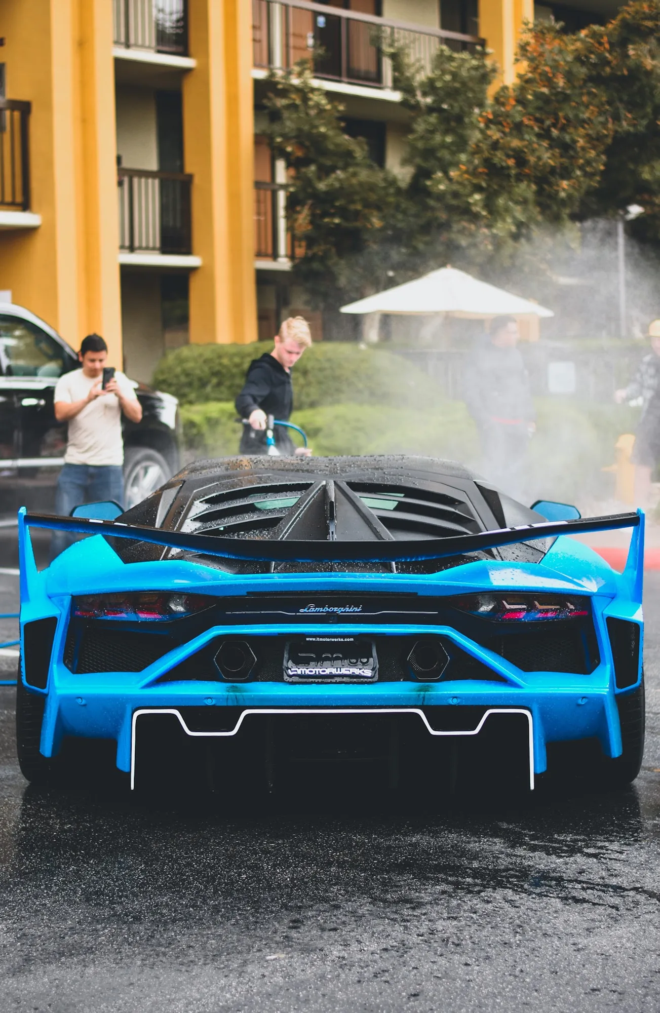 A blue sports car during an exterior wash